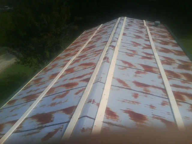 Rusted metal roof panels with new wood purlins before replacement — Storm Damage Roof Repair in West Frankfort by Roofing Brothers