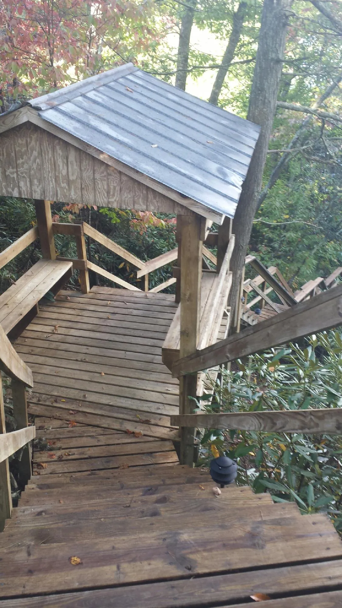 Metal roofed shelter over wooden steps on a wooded walkway — Skylight Repair & Installation work by our crew in West Frankfort
